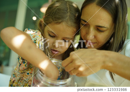 Teacher in workshop teched two girls how to assemble a thermo mosaic  123331986