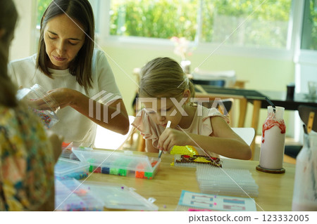 Teacher in workshop teched two girls how to assemble a thermo mosaic  123332005