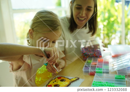 Teacher in workshop teched two girls how to assemble a thermo mosaic Teacher in workshop teched two girls how to assemble a thermo mosaic 123332088