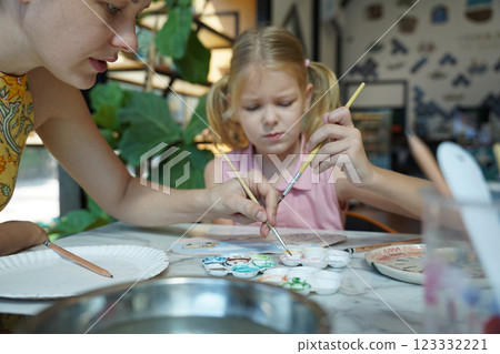 A young mother and her daughter enjoy a creative art session at home A young mother and her daughter enjoy a creative art session at home 123332221