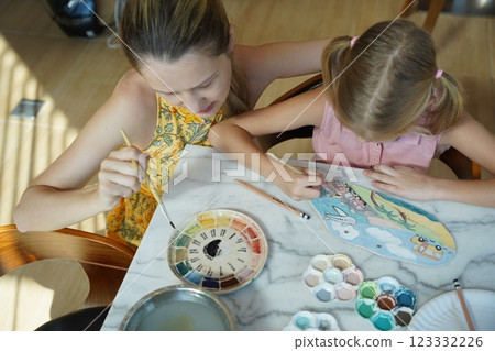 A young mother and her daughter enjoy a creative art session at home  123332226