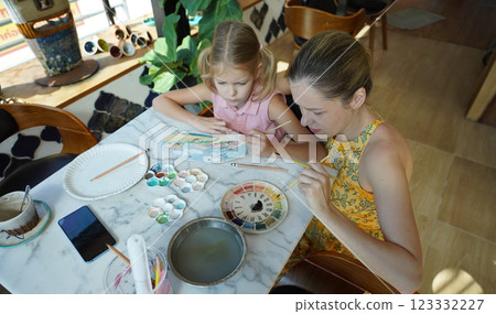 A young mother and her daughter enjoy a creative art session at home  123332227
