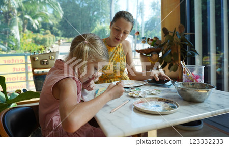 A young mother and her daughter enjoy a creative art session at home  123332233