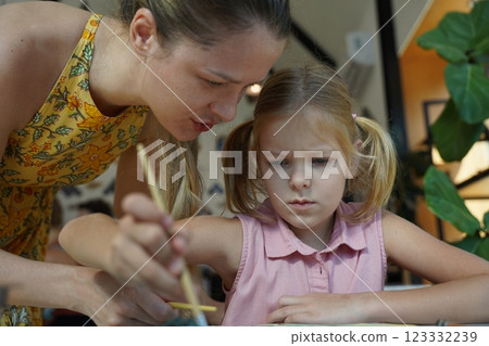 A young mother and her daughter enjoy a creative art session at home  123332239