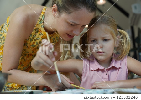 A young mother and her daughter enjoy a creative art session at home  123332240