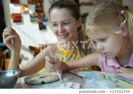 A young mother and her daughter enjoy a creative art session at home A young mother and her daughter enjoy a creative art session at home 123332244