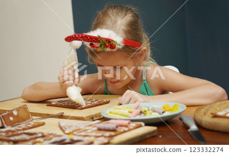 Mother and daughter at the table cooking gingerbread house for Christmas Mother and daughter at the table cooking gingerbread house for Christmas 123332274