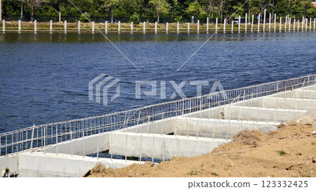 Construction of a modern pedestrian embankment on a large lake Construction of a modern pedestrian embankment on a large lake 123332425