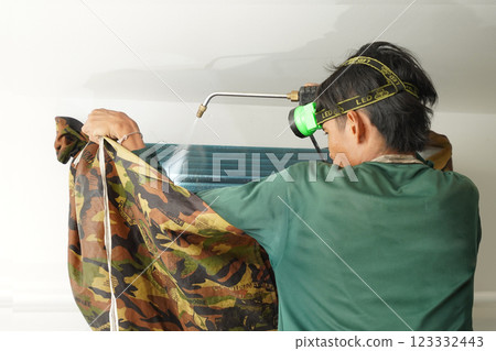 The worker cleans and repairs the air conditioner to ensure it operates properly 123332443