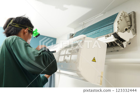 The worker cleans and repairs the air conditioner to ensure it operates properly 123332444