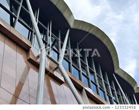 A modern tall building that features a significant amount of glass 123332458