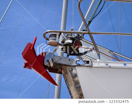 A bright red anchor is securely attached to the side of a sailing boat 123332475