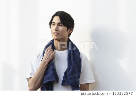 一名 20 多歲的男子肩上披著一條毛巾 123332577