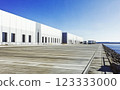 concrete parking lot and warehouse located near the sea, adjacent to a port. 123333000