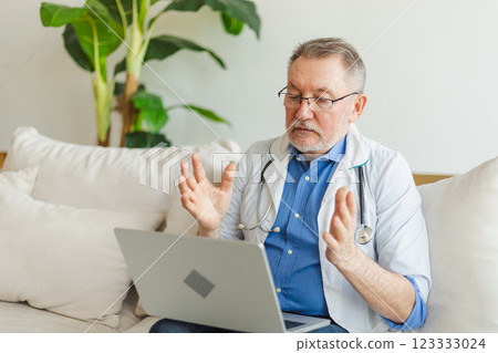 Senior man doctor with laptop talk on video call have consultation with patient. Professional senior mature healthcare expert examining patient online. Medicine healthcare medical checkup Senior man doctor with laptop talk on video call have consultation with patient. Professional senior mature healthcare expert examining patient online. Medicine healthcare medical checkup 123333024