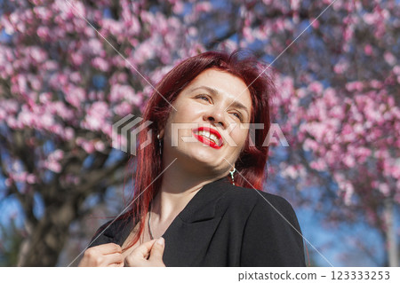 Woman with cherry flowers surrounded by blossoming trees copy space. Beauty and seasonal change and spring bloom season concept. 123333253
