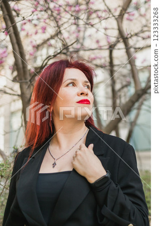 Woman with magnolia flowers surrounded by blossoming trees. Beauty and seasonal change and spring bloom season concept. Woman with magnolia flowers surrounded by blossoming trees. Beauty and seasonal change and spring bloom season concept. 123333268