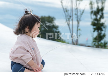 [Infants sitting on giant playground equipment] 123333702