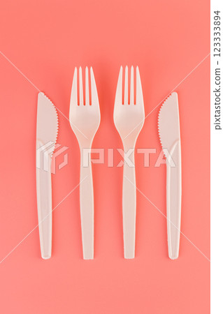 top shot close-up on soft pink background pair of plastic white knives and forks disposable tableware eco technology reusable care for planet picnic set top shot close-up on soft pink background pair of plastic white knives and forks disposable tableware eco technology reusable care for planet picnic set 123333894