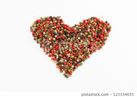 white background a pile of mixed large aromatic peppers black red and white the main seasoning for food peppercorns indian and european spices pepper laid out in the shape of a heart 123334033