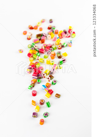 on white background in a small multi-colored sugar caramels with different flavors and patterns lie children's favorite sweets a large selection risk of caries blood sugar excess weight 123334068