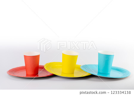 on white background there are three paper cups yellow red and blue with matching paper plates set disposable tableware standard picnic set on white background there are three paper cups yellow red and blue with matching paper plates set disposable tableware standard picnic set 123334138