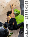 fit woman exercising on climbing wall in gym 123334143