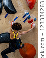 fit woman exercising on climbing wall in gym 123334263