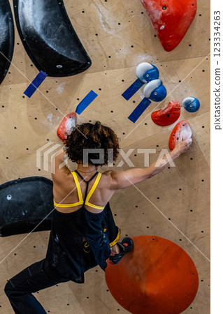 fit woman exercising on climbing wall in gym fit woman exercising on climbing wall in gym 123334263