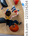 fit woman exercising on climbing wall in gym 123334264