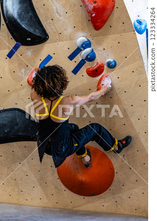 fit woman exercising on climbing wall in gym fit woman exercising on climbing wall in gym 123334264