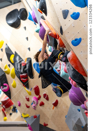 fit woman exercising on climbing wall in gym fit woman exercising on climbing wall in gym 123334266