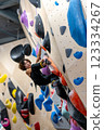 fit woman exercising on climbing wall in gym 123334267