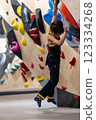 fit woman exercising on climbing wall in gym 123334268