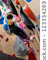 fit woman exercising on climbing wall in gym 123334269
