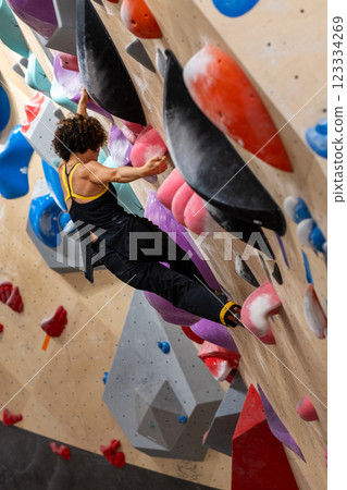 fit woman exercising on climbing wall in gym fit woman exercising on climbing wall in gym 123334269