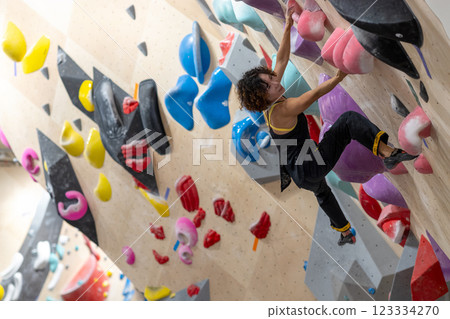 fit woman exercising on climbing wall in gym fit woman exercising on climbing wall in gym 123334270