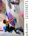 fit woman exercising on climbing wall in gym 123334271