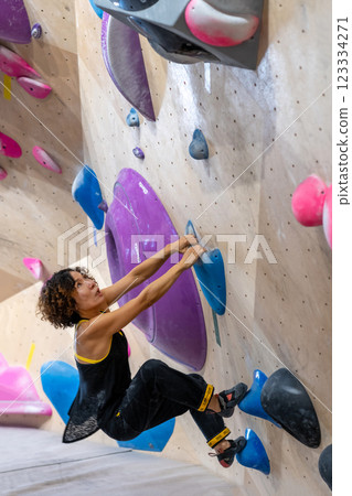 fit woman exercising on climbing wall in gym fit woman exercising on climbing wall in gym 123334271