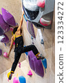 fit woman exercising on climbing wall in gym 123334272