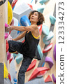 fit woman exercising on climbing wall in gym 123334273