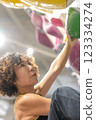 fit woman exercising on climbing wall in gym 123334274