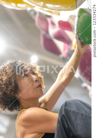 fit woman exercising on climbing wall in gym 123334274