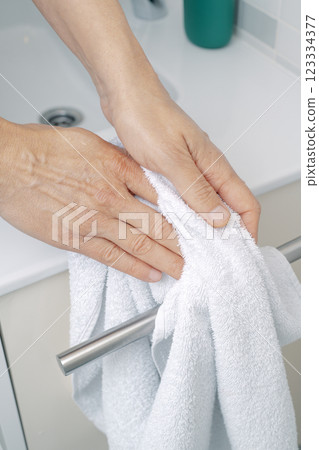 man dries his hands with a terry towel man dries his hands with a terry towel 123334377