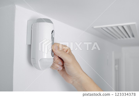 man connects the camera of a burglar alarm man connects the camera of a burglar alarm 123334378