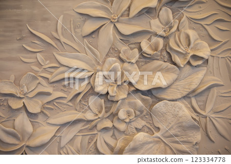 Texture of a decorative wall panel with flowers made of concrete and plaster. Texture of a decorative wall panel with flowers made of concrete and plaster. 123334778