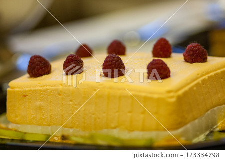 Indulge in a Delicious Mango Mousse Cake that is Topped Beautifully with Fresh Raspberries 123334798