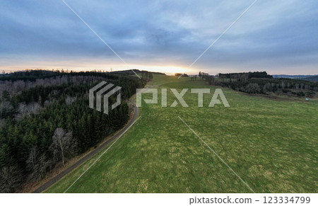 This captivating scenic landscape features rolling hills adorned by a stunning sunset view 123334799