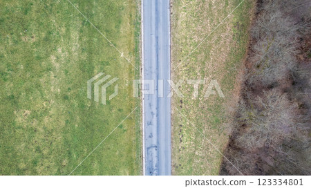 A Beautiful Aerial View of a Serene, Winding Road That Passes Through Lush Green Fields 123334801