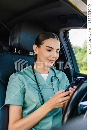 Female doctor in lab suit with a phone in hand texting to a patient Female doctor in lab suit with a phone in hand texting to a patient 123335049
